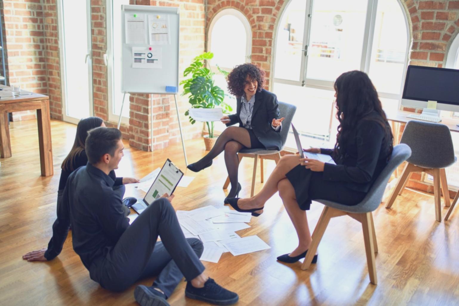 Professional consultation session with financial advisor reviewing investment documents and charts with a client in a bright office setting